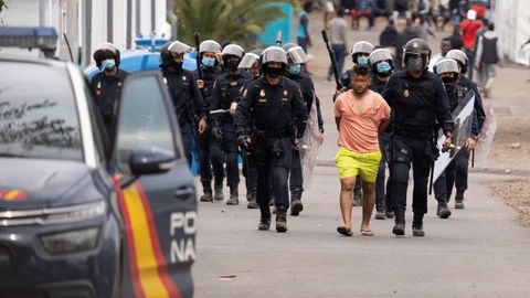 Polic�as antidisturbios trasladan a un detenido del campamento humanitario de Las Ra�ces