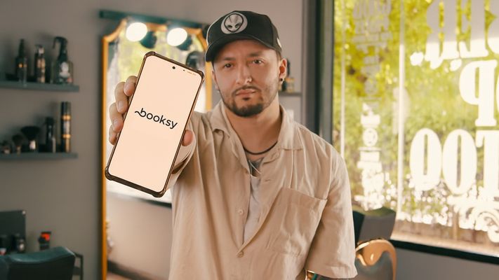 Un peluquero muestra la aplicaci�n de Booksy con la que gestiona su establecimiento