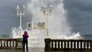 Una mujer saca fotos del temporal martimo de Gijn