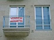 Imagen de un piso con un cartel para anunciar su venta en la capital ourensana.