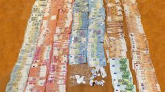 Dinero y bolsas de droga intervenidas tras el operativo en el punto de venta de drogas situado en un piso okupado en Pelamios