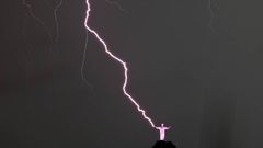 Vista de un rayo que cae en las manos del Cristo Redentor