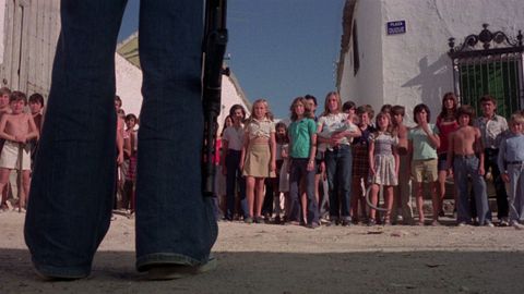 La ic�nica escena de la plaza del pueblo. Tom porta un subfusil MP-40, tan de la Segunda Guerra Mundial, aunque su guerra es contra decenas de ni�os sin el m�s m�nimo escr�pulo.