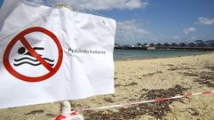 El baño sigue prohibido en la playa de A Banda do Río de Bueu con bandera roja, un cartel y precinto