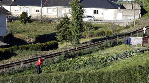Un hombre trabajando en un huerto al pie de la va del tren, en Viveiro (imagen de archivo)
