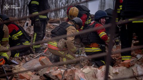 Los rescatistas retiran escombros mientras buscan personas en el lugar de un ataque militar ruso, en Sumy, Ucrania.