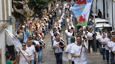 Los 140 músicos que desfilaron bajo la bandera de la Escola lucieron una camiseta inspirada en la primera que diseñó la entidad, con los colores azul y blanco, de la bandera gallega