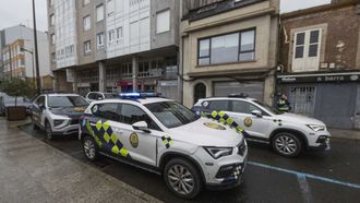 Tres vehículos patrulla custodian el edificio en el que se produjo el asalto.