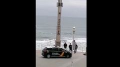 Momento en el que agentes de la Polic�a Nacional hablan con el ba�ista tras pedirle que saliera del agua, a la altura de la Escalerona
