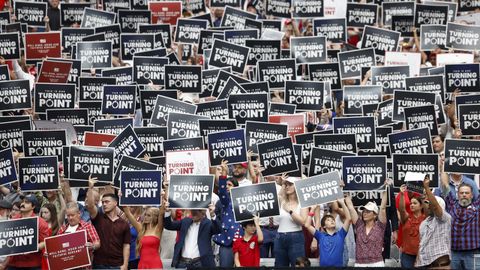 Asistentes sostienen carteles durante el ?funeral de Estado? a Charlie Kirk.