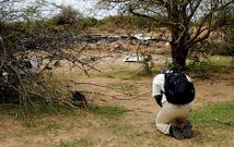 Un hombre reza arrodillado ante los restos del avi�n siniestrado cuando se dirig�a a Argel. 