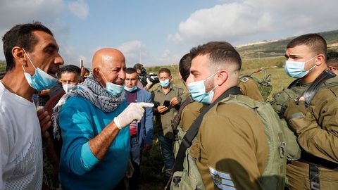 Militares y ciudadanos palestinos debatiendo sobre el coronavirus