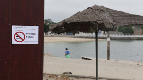 Carteles en la playa de O Preguntoiro anunciando la prohibici�n de ba�arse este semana