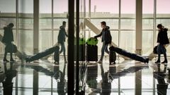 Varios pasajeros protegidos con mascarilla en una de las terminales del aeropuerto de Barcelona-El Prat