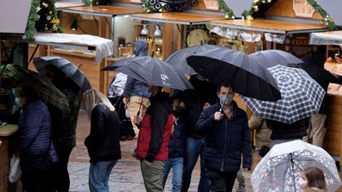  Varias personas se protegen de la lluvia con paraguas en el centro de Oviedo