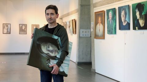 Alberto Rodr�guez posa junto a las obras de su exposici�n en el auditorio de Rianxo