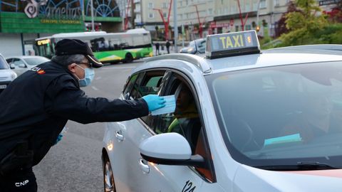 Polica Nacional, Local y Autonmica reparten mascarillas a transentes y conductores en la plaza de Amrica de Vigo