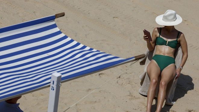 Mujer tomando el sol en la playa.