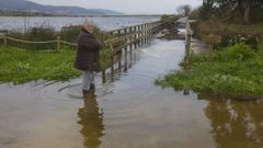 Una de las propietarias del Camping Baldayo, ayer por la ma�ana, junto a la pasarela anegada en buena parte.