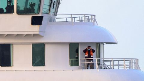 Una persona observa a trav�s de binoculares a bordo del crucero MV Hondius en el puerto de Granadilla de Abona.