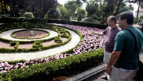 Dos hombres contemplan el reloj floral, sin agujas