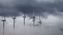 Varios aerogeneradores de la sierra de El Perd�n empiezan a quedar cubiertos por las nubes que se aproximan a la capital navarra en una jornada donde las temperaturas han bajado de forma notable.