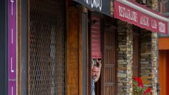 Un hostelero de Oviedo entra en su local para prepararlo ante la posibilidad de apertura.