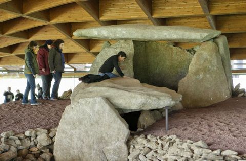 Fernando Carrera y las tres becarias accediendo al interior del dolmen de Dombate. 