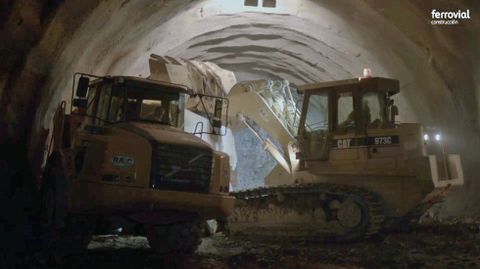 Excavadoras y camiones volquete de grandes dimensiones van sacando el material sobrante del interior del tnel a medida que avanza la excavacin
