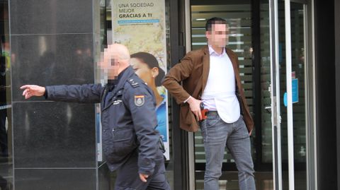 Dos polic�as, uno de ellos con la mano en la empu�adura de su arma, tras la resoluci�n del secuestro