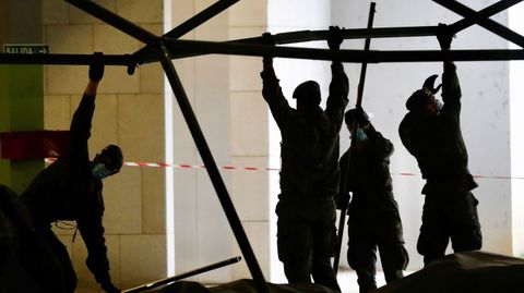 Soldados del regimiento de infanter�a n�mero 3 de la Brigada Galicia con base en Cabo Noval durante el repliegue parcial de la estaci�n de triaje instalada por el ej�rcito en uno de los aparcamientos del Hospital Universitario Central de Asturias (HUCA)