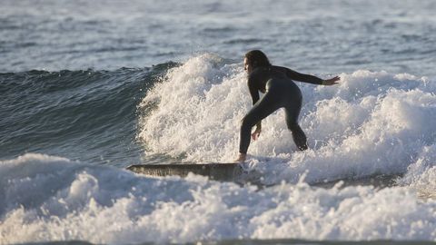 Una surfista cabalgando una ola este verano en la playa Area Maior de Malpica