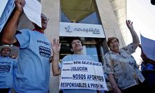 Una parte de los afectados, con uno de los escritos que entregan al retirar los fondos.