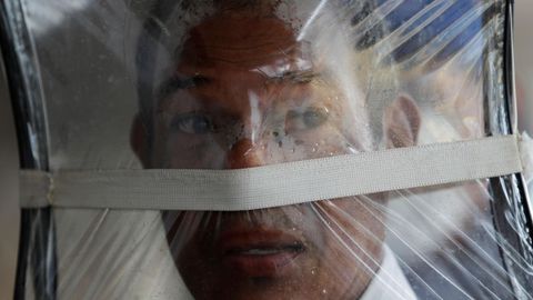 Zaul Ortega, de 53 aos, se cubre el rostro con una bolsa plstico mientras hace fila para comprar en un supermercado en Ciudad de Panam