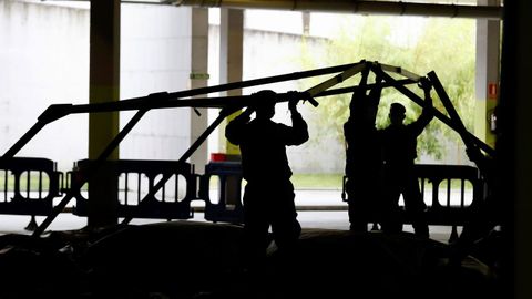 Soldados del regimiento de infanter�a n�mero 3 de la Brigada Galicia con base en Cabo Noval durante el repliegue parcial de la estaci�n de triaje instalada por el ej�rcito en uno de los aparcamientos del Hospital Universitario Central de Asturias (HUCA)