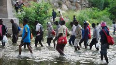Varios inmigrantes cruzan un r�o de Italia en su intento de alcanzar la frontera