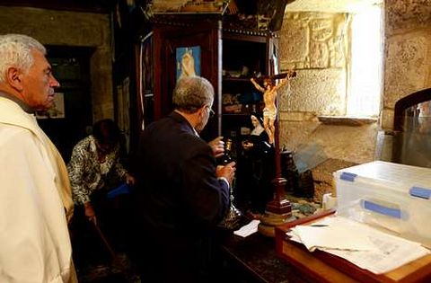 El cura y fieles de la parroquia comprueban los da�os causados en la iglesia de Moraime.