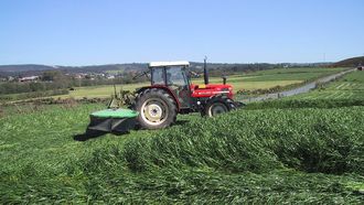 Imagen de archivo de un tractor cortando la hierba