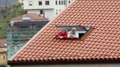 Dos personas se asoman a la ventana durante el confinamiento, que ya dura seis semanas