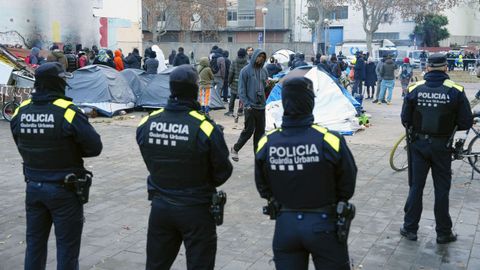 Agentes de la Polic�a Local de Badalona (Barcelona) controlan a los inmigrantes desalojados del antiguo instituto B9.