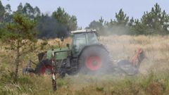 Un tractor cortando madera en el monte este martes en la Costa da Morte