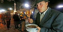 Un grupo de voluntarios reparte comida caliente entre ciudadanos con pocos recursos en las calles de Lisboa.