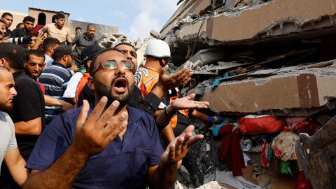 Civiles gazates y equipos de rescate intentan buscar supervivientes en un edifico bombardeado en Jan Yunis.