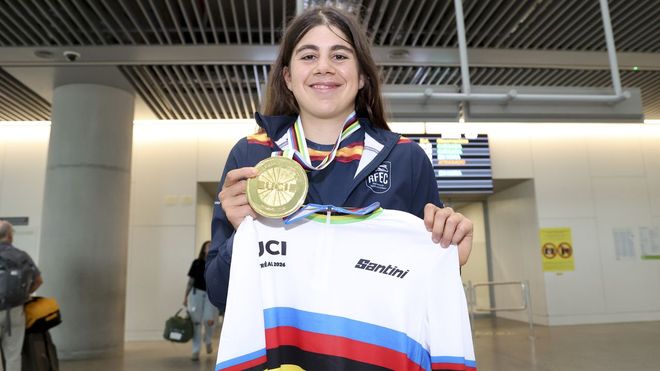 Alejandra Neira posa con la medalla y el maillot que la acreditan como campeona del mundo j&uacute;nior de ciclismo en ruta en su llegada al aeropuerto de Santiago.