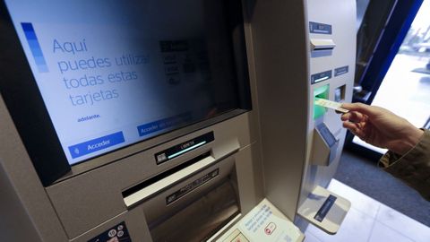 Usuario en un cajero con una tarjeta de cr�dito, en imagen de archivo.