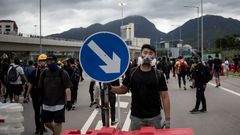 Un manifestante bloquea el acceso al aeropuerto de Hong Kong