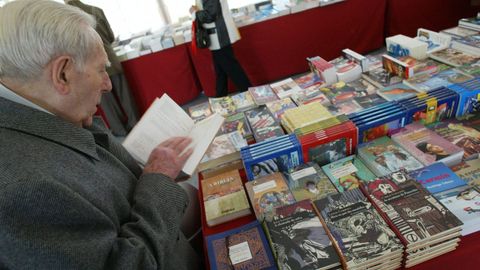 Un hombre hojea vol�menes en gallego en una feria del libro.