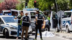 Polic�as nacionales custodian el cuerpo de una de las v�ctimas del atropello.