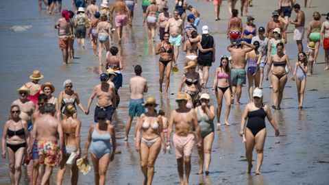 Vecinos y turistas se refrescan en la playa de Silgar.