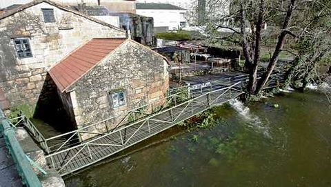 <span lang= es-es >A la vista la taberna O Mui�o y el paseo fluvial, en Caldas</span>. El nivel del Umia baj� ayer dos metros con respecto al lunes, cuando el agua ocult� el paseo y lleg� a la ventana de la taberna.